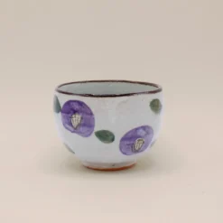 Kop med lilla blomster og brun kant