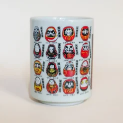 Kop med små daruma-figurer med forskellige udformninger